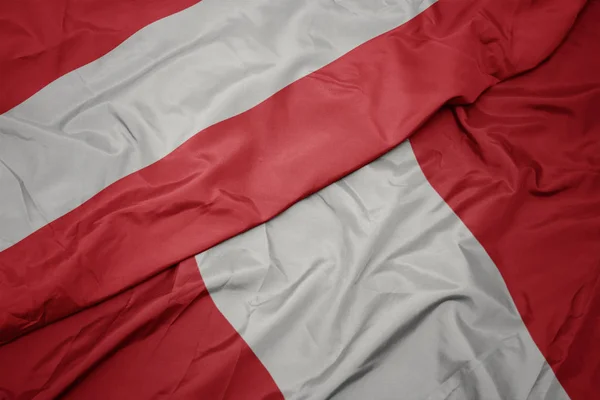 Zwaaiende vlag van Peru en nationale vlag van Oostenrijk. — Stockfoto