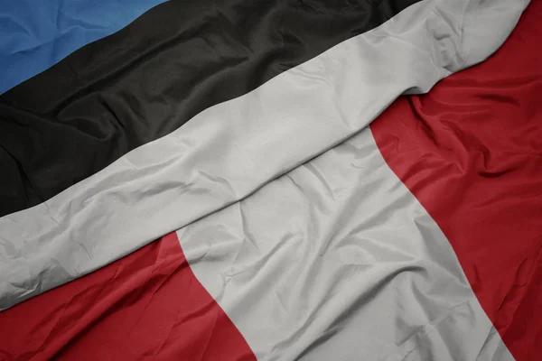 Zwaaiende vlag van Peru en nationale vlag van estonië. — Stockfoto