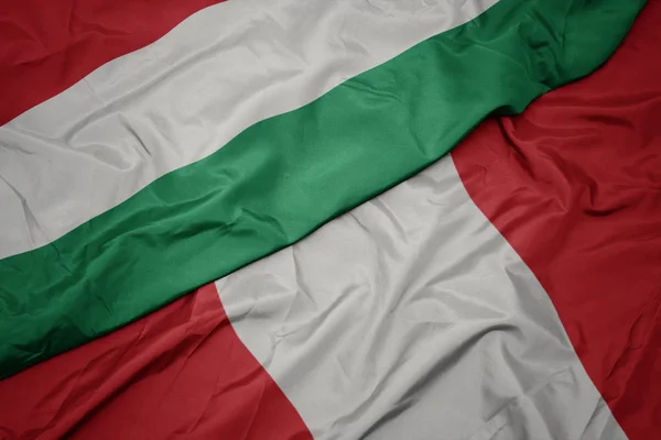Peru 'nun renkli bayrağı ve Hungary' nin ulusal bayrağı sallanıyor.. — Stok fotoğraf