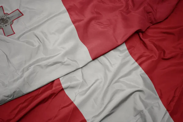 Lobogtató színes zászló a peru és a nemzeti zászló Malta. — Stock Fotó
