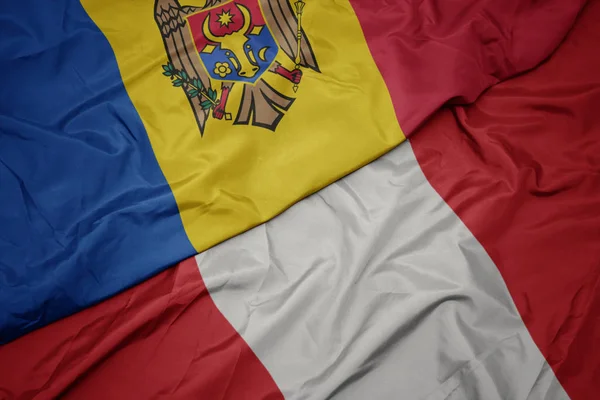 Ondeando colorida bandera de perú y bandera nacional de moldavia . —  Fotos de Stock