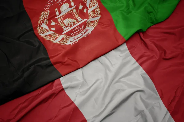 Ondeando colorida bandera de perú y bandera nacional de afganistán . —  Fotos de Stock