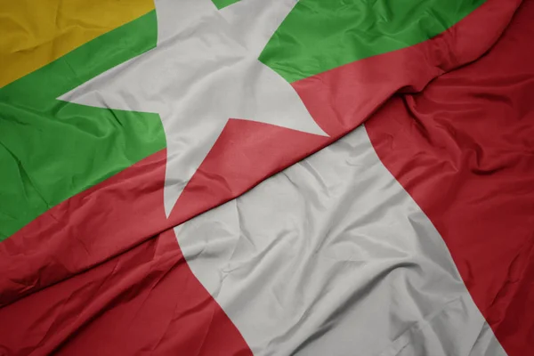 Schwenken bunte Fahne von Peru und Nationalflagge von Myanmar. — Stockfoto