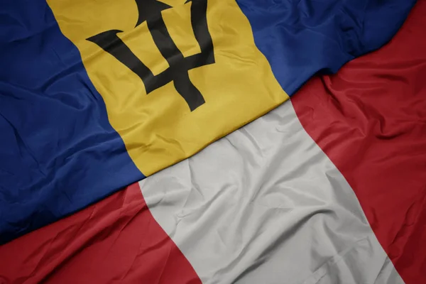 Ondeando colorida bandera de perú y bandera nacional de barbados . —  Fotos de Stock