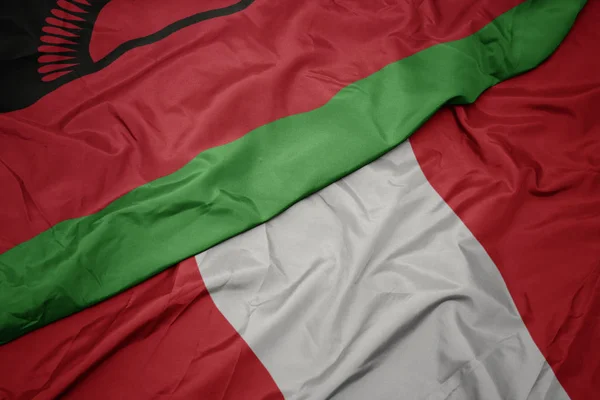 Ondeando colorida bandera de perú y bandera nacional de malawi . — Foto de Stock