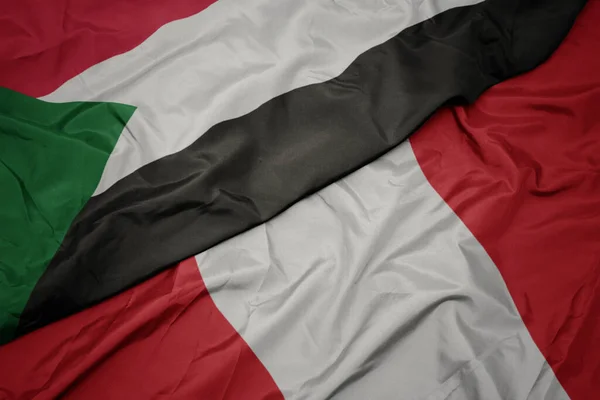 Ondeando colorida bandera de perú y bandera nacional de sudan . —  Fotos de Stock