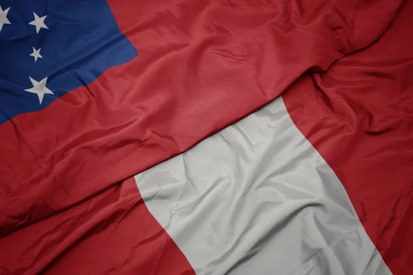 Размахивая красочным флагом Перу и национальным флагом Самоа  . — стоковое фото