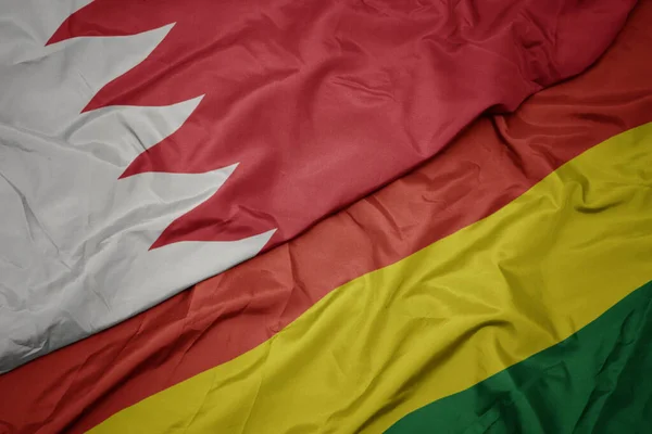 waving colorful flag of bolivia and national flag of bahrain. macro