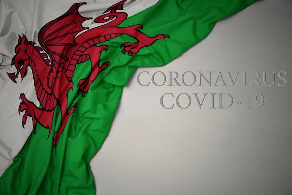 在灰色背景上挥动着色彩艳丽的海象国旗 上面印有科罗纳维的文字Covid — 图库照片