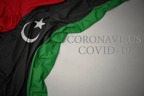 Κυματίζει Πολύχρωμη Εθνική Σημαία Της Libya Ένα Γκρι Φόντο Κείμενο — Φωτογραφία Αρχείου