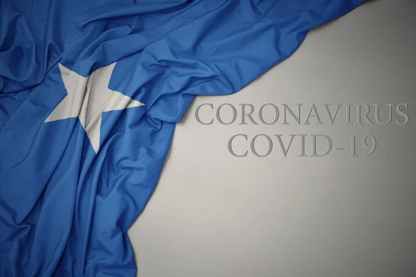 Размахивая Красочным Национальным Флагом Сомали Сером Фоне Текстом Coronavirus Covid — стоковое фото