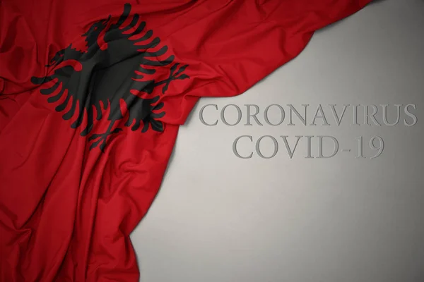 Размахивая Красочным Национальным Флагом Альбании Сером Фоне Текстом Coronavirus Covid — стоковое фото