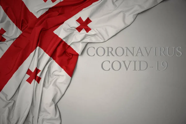 Размахивая Красочным Национальным Флагом Грузии Сером Фоне Текстом Coronavirus Covid — стоковое фото