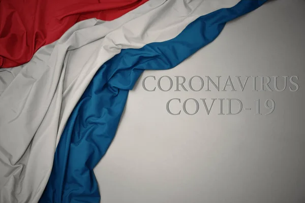 Размахивая Красочным Национальным Флагом Люксембурга Сером Фоне Текстом Coronavirus Covid — стоковое фото