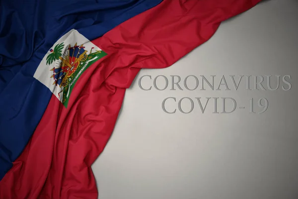 在灰蒙蒙的背景上挥动着五彩缤纷的海地国旗 文字上写着Coronavirus Covid — 图库照片