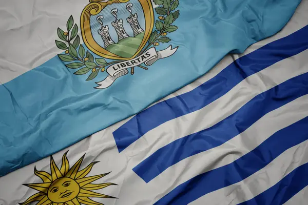 Κυματίζει Πολύχρωμη Σημαία Της Uruguay Και Εθνική Σημαία Του Σαν — Φωτογραφία Αρχείου