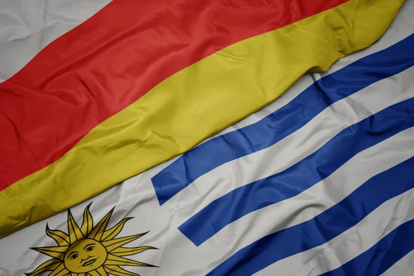Κυματίζει Πολύχρωμη Σημαία Της Uruguay Και Εθνική Σημαία Της Νότιας — Φωτογραφία Αρχείου
