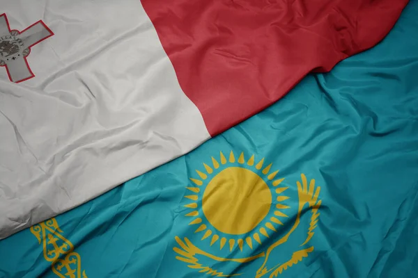 カザフスタンのカラフルな旗とマルタの国旗を振っています マクロ — ストック写真