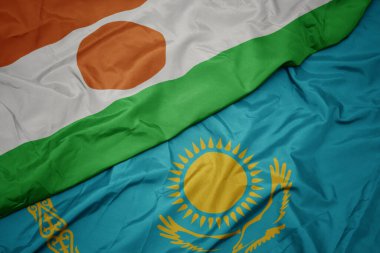 Kazakistan 'ın renkli bayrağı ve Nijer' in ulusal bayrağı sallanıyor. makro