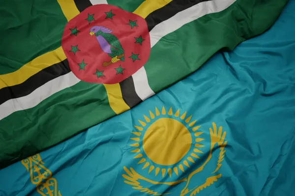 waving colorful flag of kazakhstan and national flag of dominica. macro