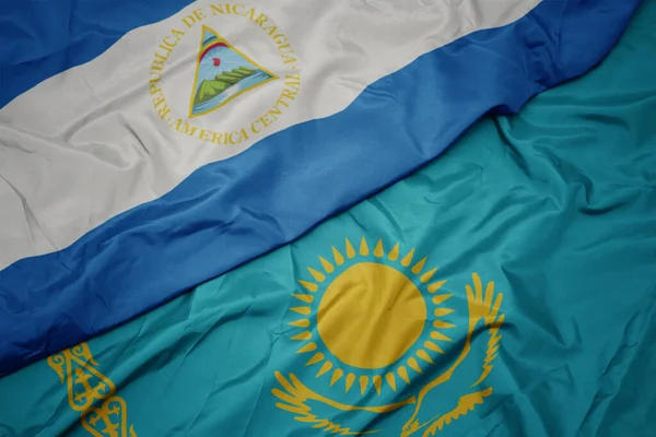 カザフスタンのカラフルな旗とニカラグアの国旗を振っています マクロ — ストック写真