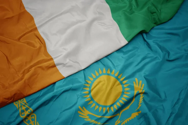 カザフスタンのカラフルな旗とコート ディビオールの国旗を振っています マクロ — ストック写真