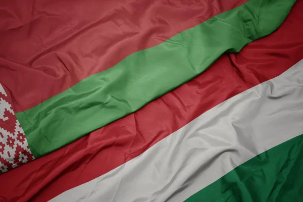ハンガリーのカラフルな旗とベラルーシの国旗を振っています マクロ — ストック写真