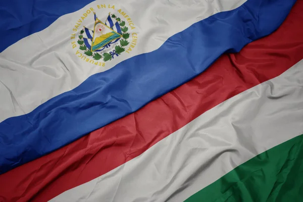 ハンガリーのカラフルな旗とレサルヴァドールの国旗を振っています マクロ — ストック写真