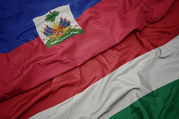 Κυματίζει Πολύχρωμη Σημαία Της Ουγγαρίας Και Εθνική Σημαία Της Αϊτής — Φωτογραφία Αρχείου