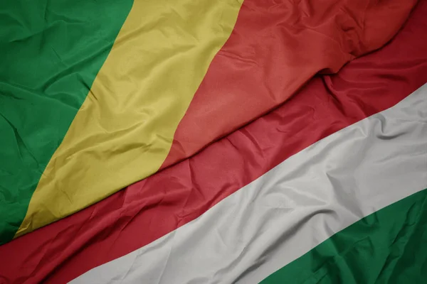 waving colorful flag of hungary and national flag of republic of the congo. macro