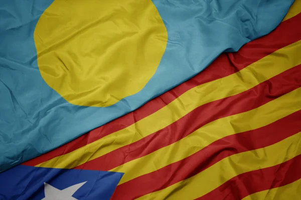 waving colorful flag of catalonia and national flag of Palau . macro