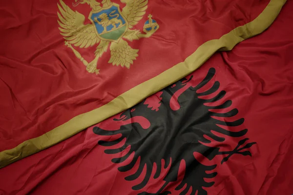 waving colorful flag of albania and national flag of montenegro. macro