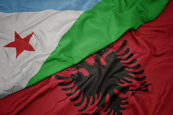 waving colorful flag of albania and national flag of djibouti. macro