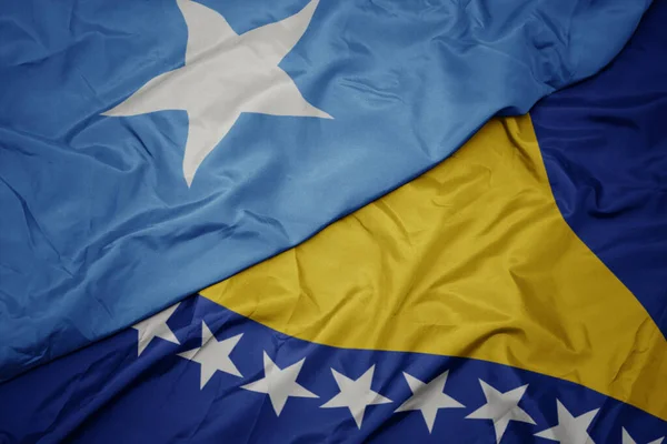 ボスニア ヘルツェゴヴィナのカラフルな旗とソマリアの国旗を振っています マクロ — ストック写真