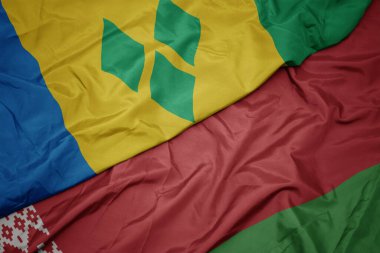 Beyaz Rusya 'nın renkli bayrağını sallıyor ve ulusal Saint Vincent bayrağını ve el bombalarını sallıyor. makro