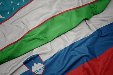 Slovenistan 'ın renkli bayrağı ve Özbekistan' ın ulusal bayrağı sallanıyor. makro