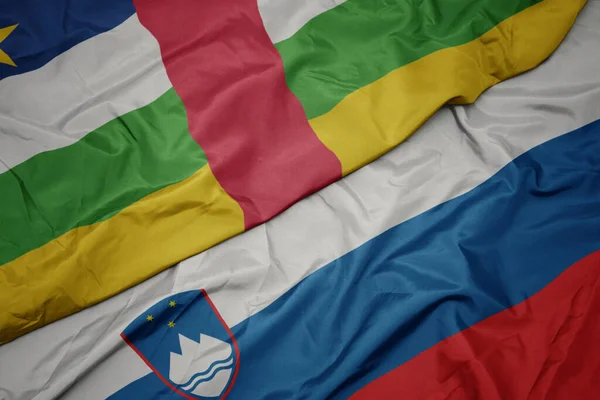 waving colorful flag of slovenia and national flag of central african republic. macro