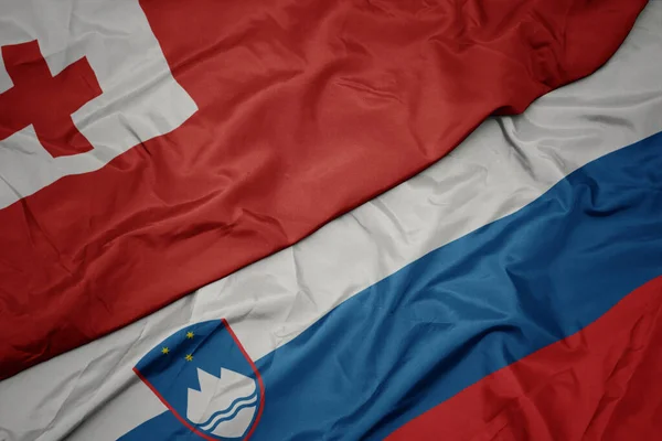 スロベニアのカラフルな旗とトンガの国旗を振っています マクロ — ストック写真