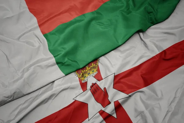 北アイルランドのカラフルな旗とマダガスカルの国旗を振っています マクロ — ストック写真