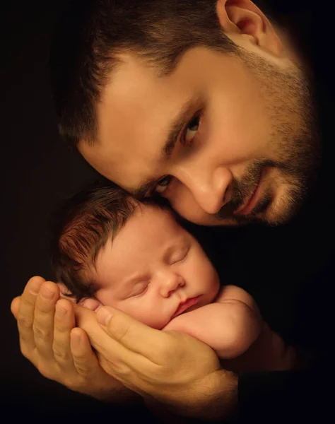 Kleines 15 Tage altes Baby liegt sicher auf Papas Armen, vor schwarzem Hintergrund — Stockfoto