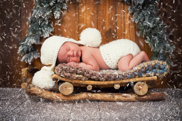 De baby slaapt in houten sleeën. New years Eve — Stockfoto