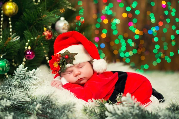 Портрет новонародженої дитини в одязі Санта лежить під ялинкою . — стокове фото
