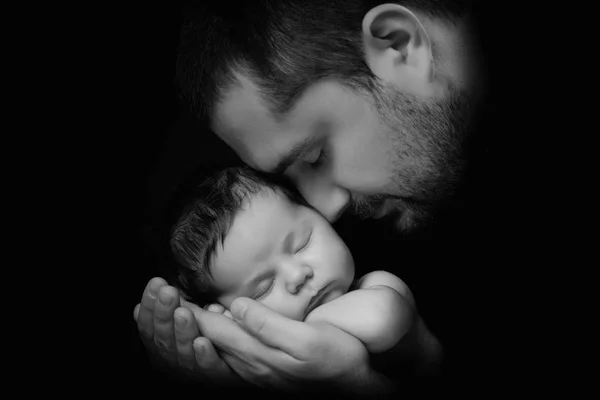 Papá abraza a su bebé recién nacido. El amor de mi padre. Retrato de primer plano sobre fondo negro —  Fotos de Stock