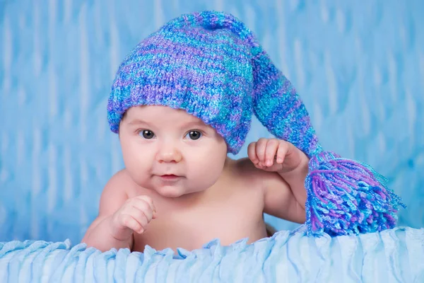 Recién nacido en gorra de punto sobre fondo azul . —  Fotos de Stock