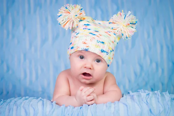 Recién nacido en gorra de punto sobre fondo azul . — Foto de Stock