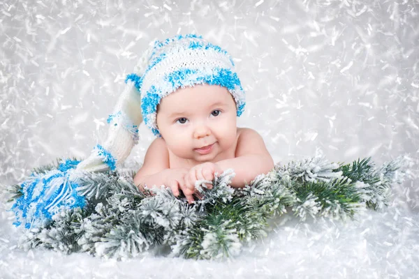 Newborn baby in a knitted cap. Snow background — Stock Photo, Image