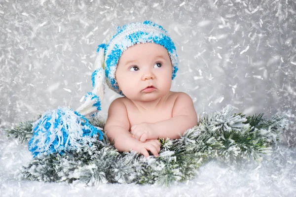 Newborn baby in a knitted cap. Snow background — Stock Photo, Image