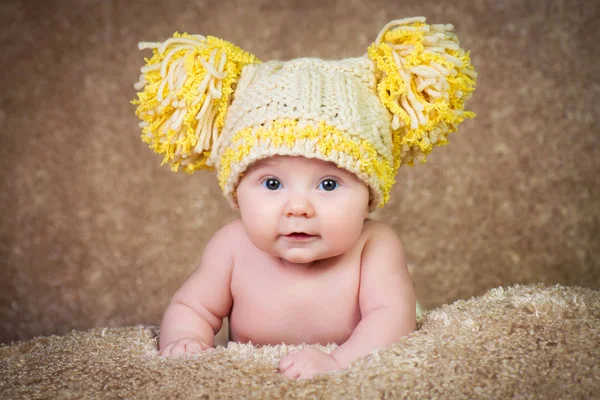 Recién nacido en sombrero de invierno de punto sobre un fondo beige . —  Fotos de Stock