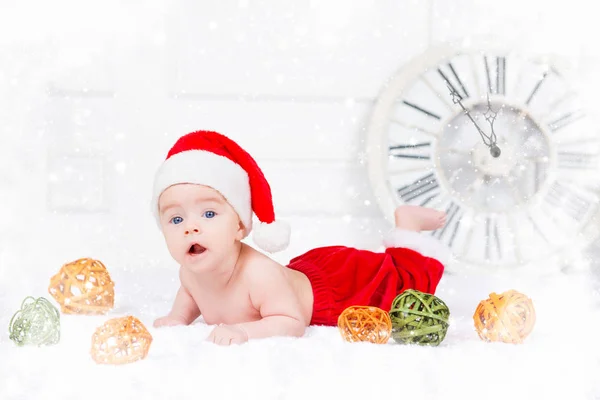Engraçado bebê de Natal em traje de Papai Noel deitado no fundo branco — Fotografia de Stock