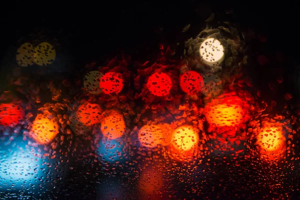 Chuva cai na janela com luzes bokeh rua . — Fotografia de Stock